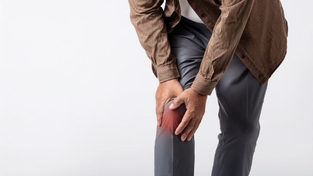 痛みのある膝に手を当てる男性